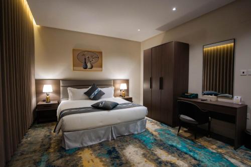 a hotel room with a bed and a desk at iqama mumayyaza الإقامة المميزة للشقق المخدومة - إقتصادي in Tabuk