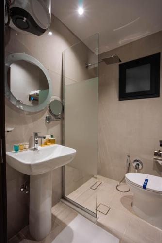 a bathroom with a sink and a toilet and a mirror at iqama mumayyaza الإقامة المميزة للشقق المخدومة - إقتصادي in Tabuk