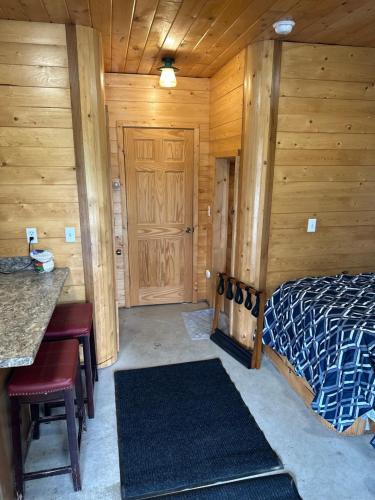 a bedroom with a bed and a wooden wall at Modern studio Cabin in Tok