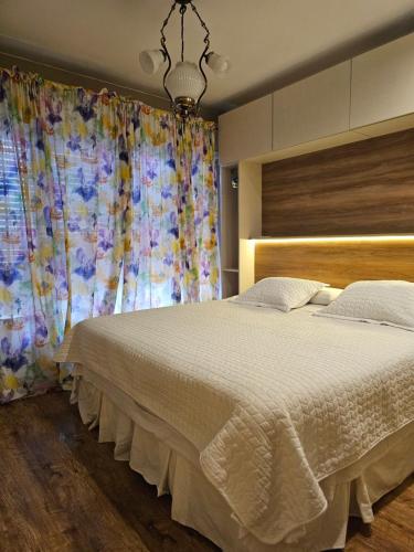 a bedroom with a large white bed with a window at APART ALVARADO microcentro in Salta