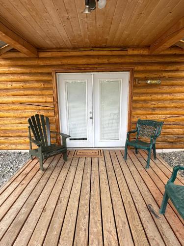 two chairs sitting on a porch of a cabin at Modern studio Cabin in Tok