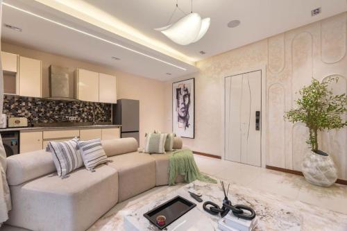 a living room with a large couch and a kitchen at Bridge Apartment Lagos in Lekki