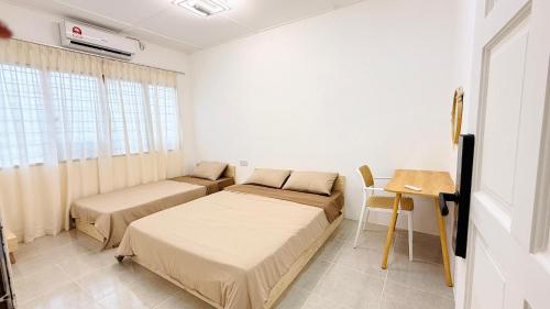 a room with two beds and a table and a window at Leisure29 Suites - Setali - 7pax in Kuantan