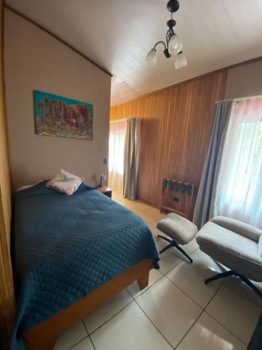 a bedroom with a blue bed and a chair at Cala Lodge in Monteverde Costa Rica