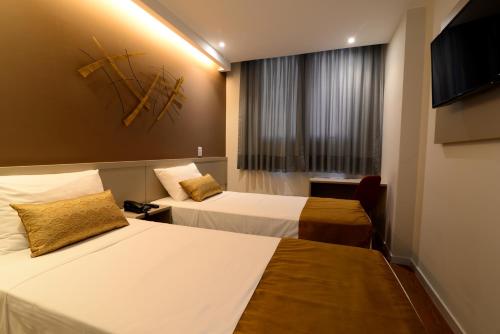 Habitación de hotel con 2 camas y TV de pantalla plana. en Easy Hotel Cachoeiro de Itapemirim by Atlantica, en Cachoeiro de Itapemirim