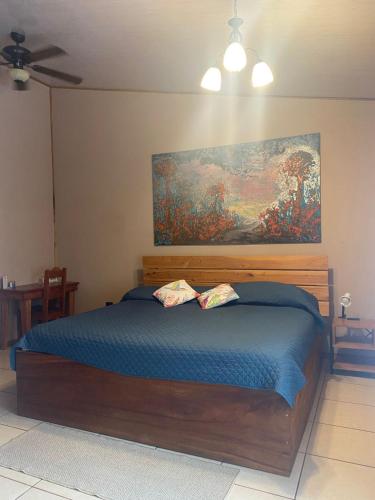 a bedroom with a bed with a painting on the wall at Cala Lodge in Monteverde Costa Rica