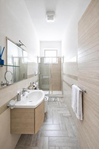 a white bathroom with a sink and a shower at Viva Vacanze in Porto Cesareo