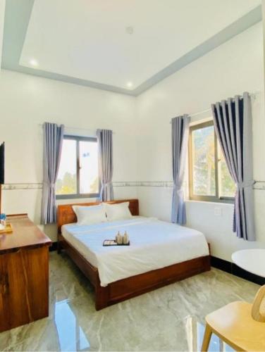 a bedroom with a large bed with blue curtains at Moonlight House in Cu Lao Thu