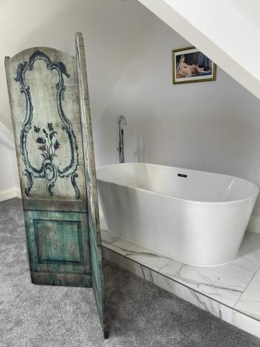 a white bath tub sitting in a bathroom at Willow Lodge in Kilham