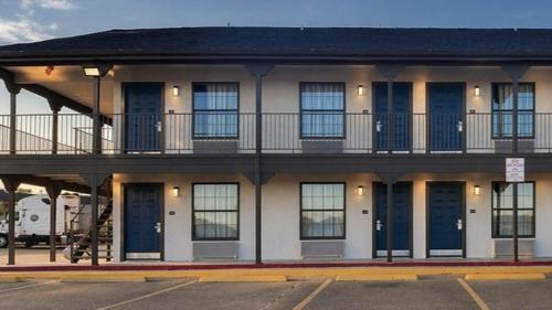 a building with blue doors and a balcony at Studio 6 Suites Mesquite, TX – Gross Rd. in Mesquite