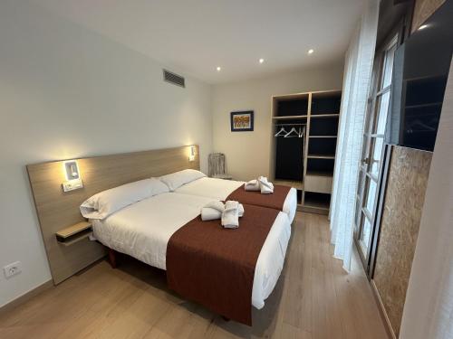 a bedroom with a large bed with towels on it at Apartamentos Los 5 Sentidos in Grado