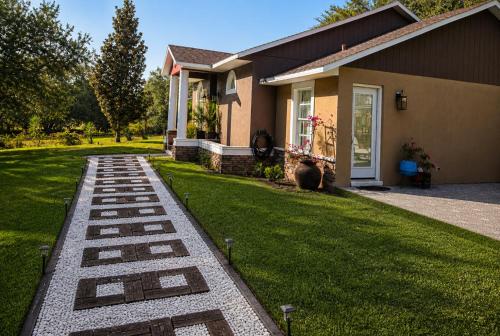a house with a grass yard with a pathway at Serene Mountain Retreat With Pool in Clermont