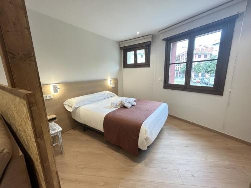 a small bedroom with a bed and a window at Apartamentos Los 5 Sentidos in Grado