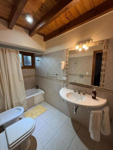 a bathroom with a sink and a toilet and a tub at Ayelen Andina in Esquel