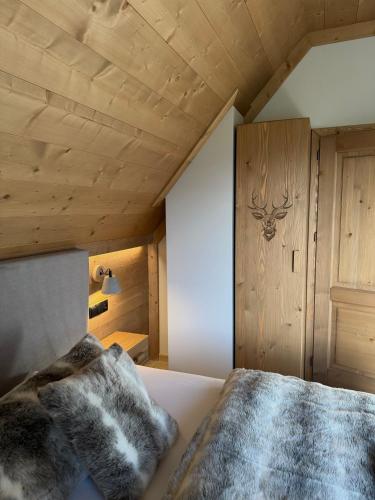 a bedroom with a bed with a wooden ceiling at Kotlina 11 in Murzasichle