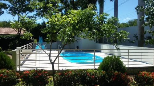 a swimming pool with a white fence around it at Pousada Jubaia in Bonito