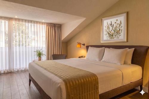 a bedroom with a large bed and a large window at Adana Plaza Hotel in Adana