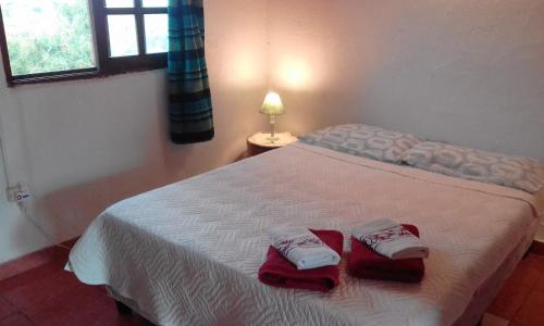 a bedroom with a bed with red towels on it at Mini Apartamentos in Neptunia