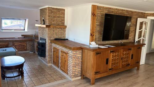 a living room with a tv and a brick fireplace at Kampenhout appartement met terras en 4 slaap kamers in Kampenhout