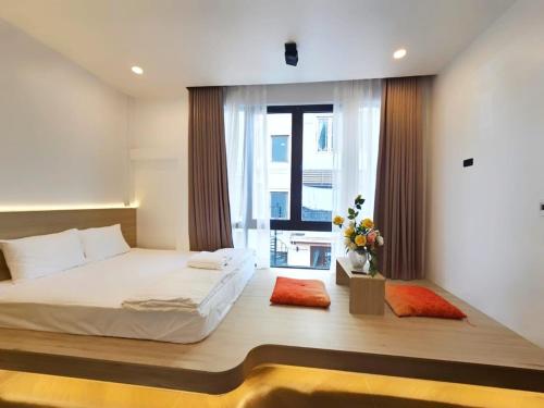 a bedroom with a large bed and a window at Serene Residence in Vientiane