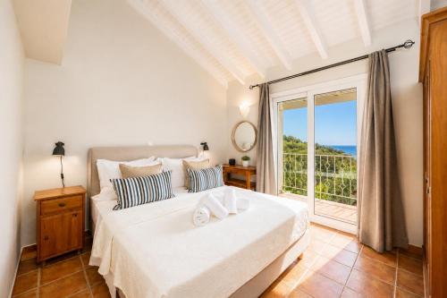 a bedroom with a bed and a large window at Villa Gardenia in Vlachopoulátika