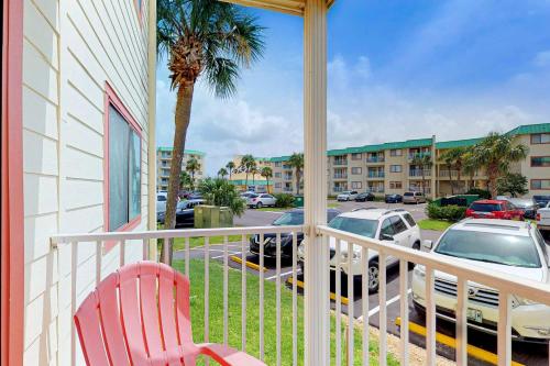 a balcony with a red chair and a parking lot at Plantation East #3117 in Gulf Highlands