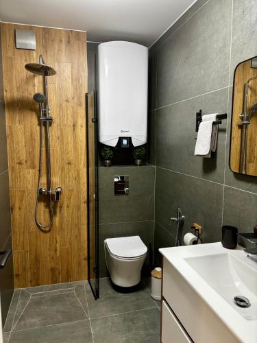 a bathroom with a shower and a toilet and a sink at Arena Apartment in Gotse Delchev