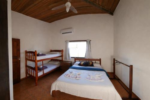 a bedroom with two twin beds and a window at POUSO DO BEIJA FLOR in Paraty