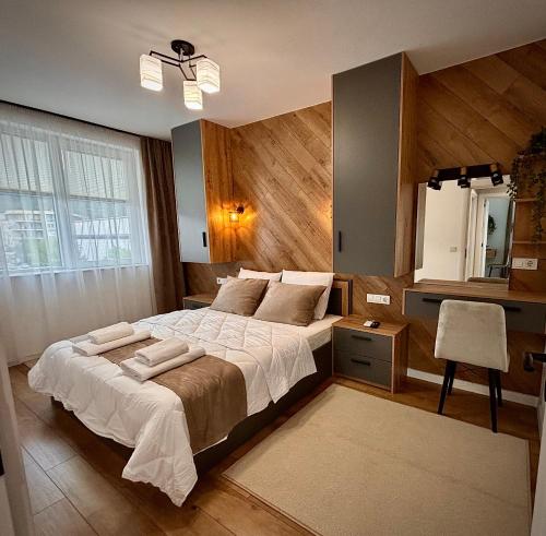 a bedroom with a large bed and a desk at Arena Apartment in Gotse Delchev