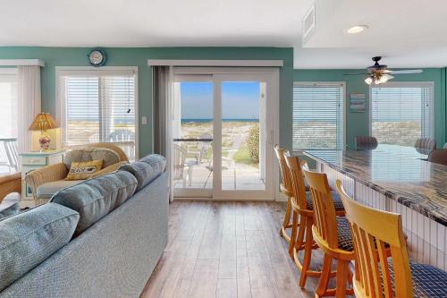 a living room with a couch and a table with chairs at #1131 The Mermaid Pad in Gulf Highlands