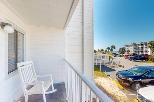 a white porch with a white chair and a car at Plantation East #1110 in Gulf Shores