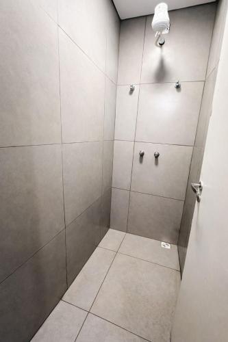 a walk in shower with gray walls and tiled floors at sleep airport congonhas in São Paulo