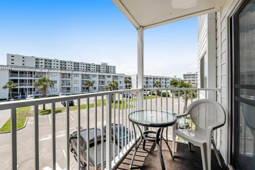 a balcony with a table and chairs and a building at Condo by the beach with Gulf views plus shared pool in Fort Morgan