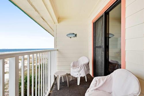 a balcony with two chairs and a table at Waterfront Gulf condo with beach access shared pool in Fort Morgan