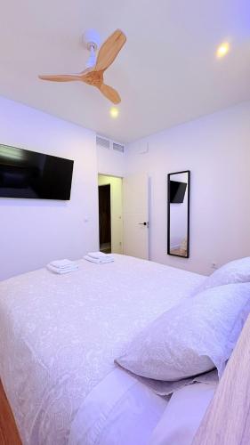 a bedroom with a bed with a ceiling fan at Apartamento Luxe Triana in Seville