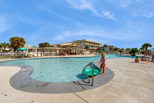 a little girl standing in front of a swimming pool at Plantation East #2314 in Gulf Shores