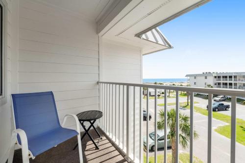a blue chair on a balcony with a view of the ocean at Plantation East #2314 in Gulf Shores