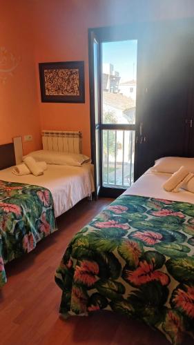 a room with two beds and a window with a view at enZamorarte in Zamora