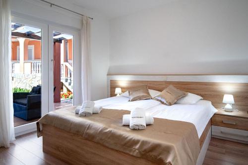 a bedroom with a large bed with towels on it at Apartments Mistral in Lopar