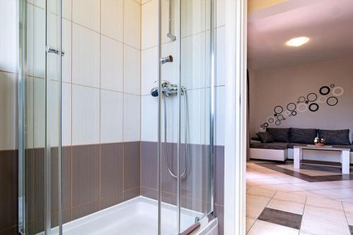 a bathroom with a shower and a tub at Apartments Mistral in Lopar