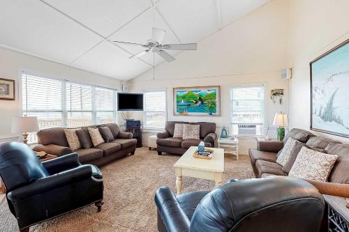 a living room with leather furniture and a ceiling fan at Fine Fish House in Gulf Highlands