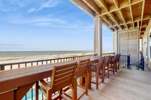 a row of chairs on a balcony overlooking the ocean at Beachfront dog-friendly home with private pool sundeck and elevator in Fort Morgan