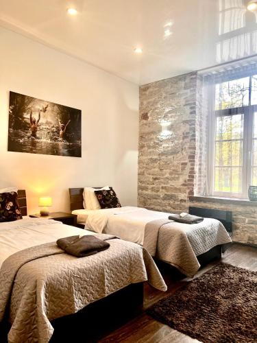 ein Schlafzimmer mit zwei Betten und einer Steinwand in der Unterkunft Vabriku 6 Apartment with sauna in Rakvere