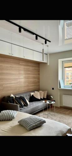 a living room with a bed and a couch at Sandstone Residence - Modern Apartment - 5 min Walk to Beach in Liepāja