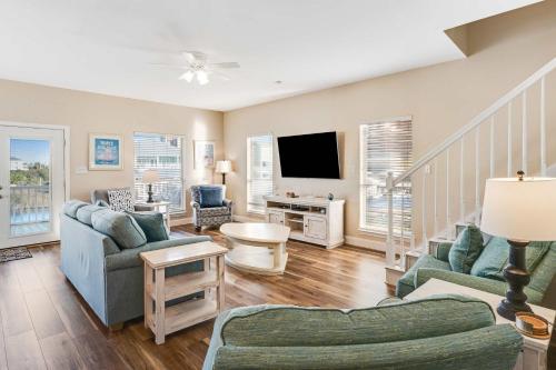 a living room with two couches and a tv at Beach Haven by Meyer Vacation Rentals in Gulf Shores