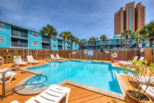 a swimming pool with chaise lounge chairs and a resort at Beautiful condo with shared pools full kitchen private washer dryer in Gulf Shores