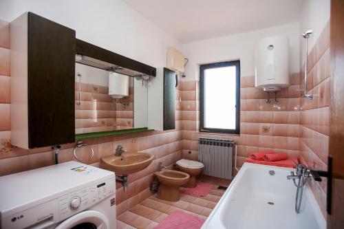 a bathroom with a washing machine and a sink at Apartment Tia in Fažana