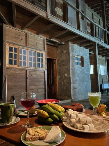 a table with plates of food and a glass of wine at Morada do Sol Petar in Iporanga