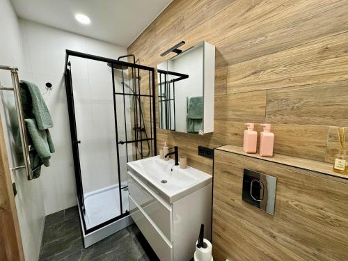 a bathroom with a sink and a mirror at Sandstone Residence - Modern Apartment - 5 min Walk to Beach in Liepāja
