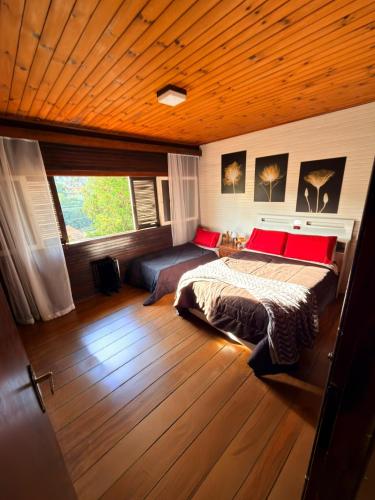 a bedroom with a bed and a window at Recanto MJ in Campos do Jordão